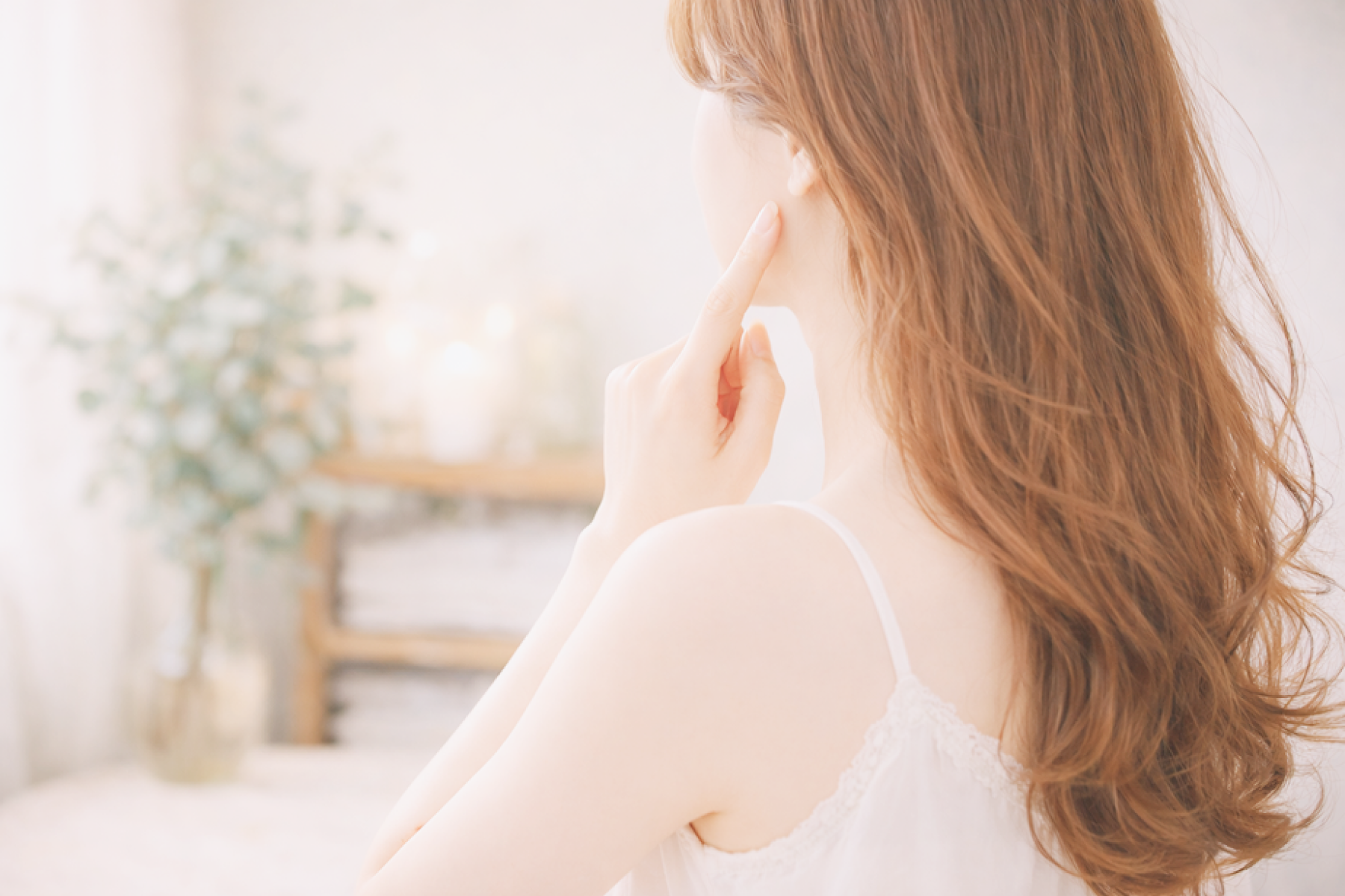 頬に触れながら振り返る女性